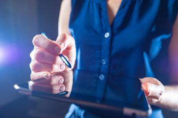 Poster - an unrecognizable woman with a tablet and a stylus. a woman uses an electronic tablet. a businesswom