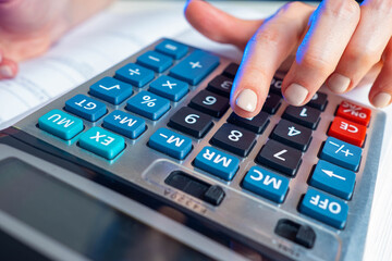 Poster - Female CEO or businesswoman counts on a calculator. Calculations in business. Financial calculations. The work of an accountant. Business audit. Checking the correctness of calculations.