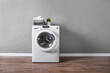 Clothes washing machine in grey laundry room