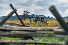 Civil War Cannon In Field With Blurred Fence In Front
