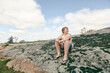 Happy caucasian boy sitting on large rock in National Park