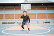 a basketball player performs a low dribble between the legs dribble with the ball while practicing basketball