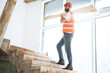 © fotofabrika - Builder man in hardhat carrying timber on building site, close up .