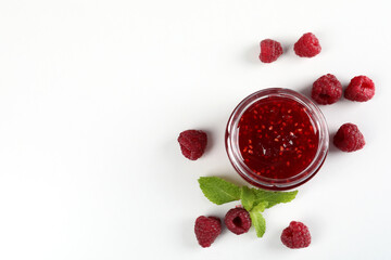 Wall Mural - Jar of raspberry jam with ingredients on white background