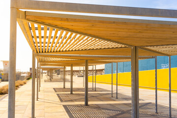 Close-up of huts with wooden roofs to provide shade in front of the port of the Forum in barcelona