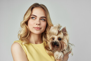 Wall Mural - beautiful woman in a yellow dress fun a small dog isolated background