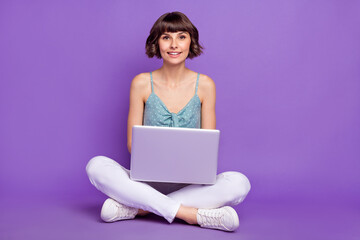 Sticker - Portrait of attractive cheerful girl sitting using laptop typing email isolated over bright violet purple color background