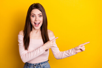 Sticker - Photo of happy excited crazy amazed funky girl point fingers copyspace advertising product isolated on yellow color background