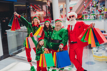 Wall Mural - Portrait of attractive cheerful cool group elfs buying gifts spending eve advent festal day time at shopping mall indoors