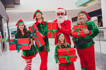 Wall Mural - Portrait of attractive cheerful stylish funky group elfs holding giftboxes shopping eve festal time advent spirit at store indoors