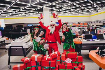 Sticker - Photo of good mood funky santa claus assistants wear costumes smiling shooting gun holding cash fans indoors shopping center