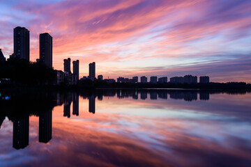 The river in the city Park reflects the city skyline against a beautiful and spectacular sunset backdrop.