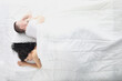 © H_Ko - Young man and woman sleeping backs to each other in white bed top view