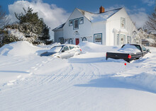 Unplowed Driveway Of A Traditional Older Home After A Blizzard In A North American Suburban Neighborhood.