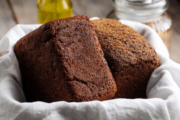 Side view on two loafs of rye bread in a basket with napkin