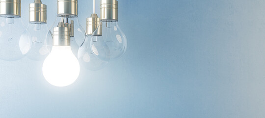 glowing light bulb on blurry wide blue wall background. idea, innovation, solution and invention con