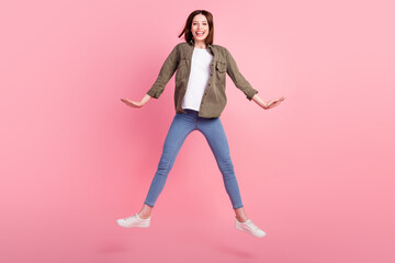 Wall Mural - Full length photo of funny brunette hairdo lady jump wear green shirt jeans sneakers isolated on pink color background