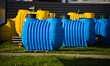 Plastikowe zbiorniki do przydomowych oczyszczalni ścieków . Żółty , niebieski . Beczka metalowy płot . Plastic tanks for home sewage treatment plants. Yellow, blue. Barrel, metal fence. 
