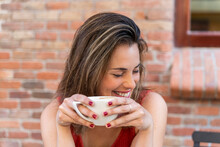 Portrait Of Laughing Young Woman With Cup Of Coffee