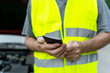 © VITTA GALLERY/Westend61 - Close up of a senior man standing at his broken car wearing a safety vest and using his smartphone
