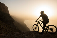 Spain, Lanzarote, Mountainbiker On A Trip At The Coast At Sunset Enjoying The View