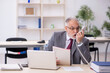 © Elnur - Old male employee working in the office