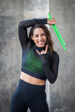 Portrait Of Happy Young Woman Holding Pound Exercise Sticks