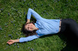 © Benjamin Egerland/Westend61 - Portrait of happy young woman relaxing on a meadow