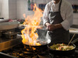 © Christian Vorhofer/Westend61 - Cook cooking in kitchen with burning pan