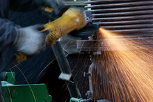 Close-up Of Worker Using Angle Grinder In A Factory