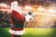 © alphaspirit - Santa Claus with a soccer ball in his hands inside a soccer stadium