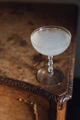 cloudy cacao water cocktail in vintage glass on burl wood table 