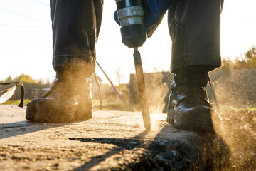 A male installer works with a hammer drill. Construction works.