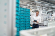© Daniel Ingold/Westend61 - Smiling businessman using tablet in a factory hall with boxes