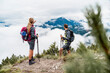 © Daniel Ingold/Westend61 - Young couple on a hiking trip in the mountains looking at view, Herzogstand, Bavaria, Germany