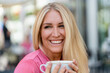 © Daniel Ingold/Westend61 - Portrait of happy blond woman with cup of coffee