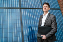 Businessman Holding Folder Standing In Front Of Solar Panels