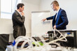 © Daniel Ingold/Westend61 - Two businessmen in office discussing at flip chart