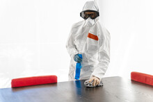 Woman Wearing Protective Clothes, Sanitizing Her Home, Wiping Table