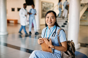 Wall Mural - Happy Asian nursing student at medical university looking at camera.