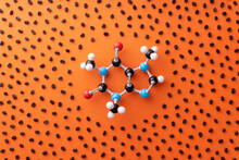 Directly above view of caffeine chemical formula with roasted coffee beans over orange background