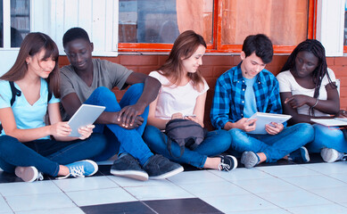 Sticker - Diversity Students Friends Happiness Concept. Five schoolmates seated in the school hallway