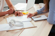© BONNINSTUDIO/Westend61 - Close-up of colleagues working together at desk in office discussing papers