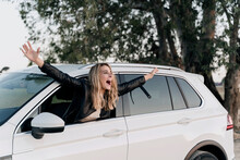 Blond woman in white car leaning out of the window and scream