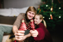 Father And Daughter Showing Red Christmas Ornaments