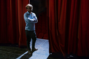 Portrait of man standing on theatre stage
