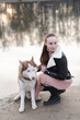 © Westend61 - Portrait of woman and her husky at water's edge