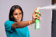 young lady spraying an insecticide