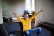 © Jo Kirchherr/Westend61 - Mature man sitting on couch at home cheering