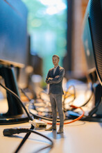 Businessman Figurine Standing Amidst Computer Cables